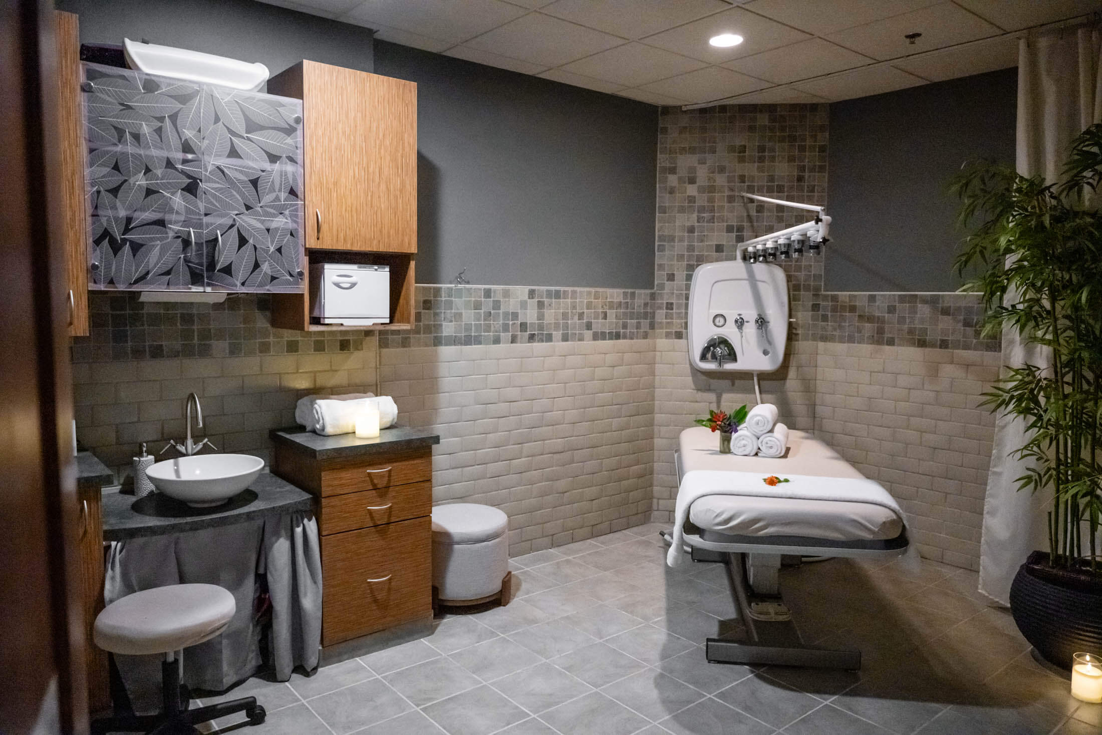 Spa room with massage table and sink.