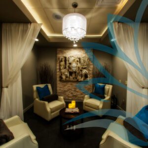 Elegant lounge with white chairs and chandelier.