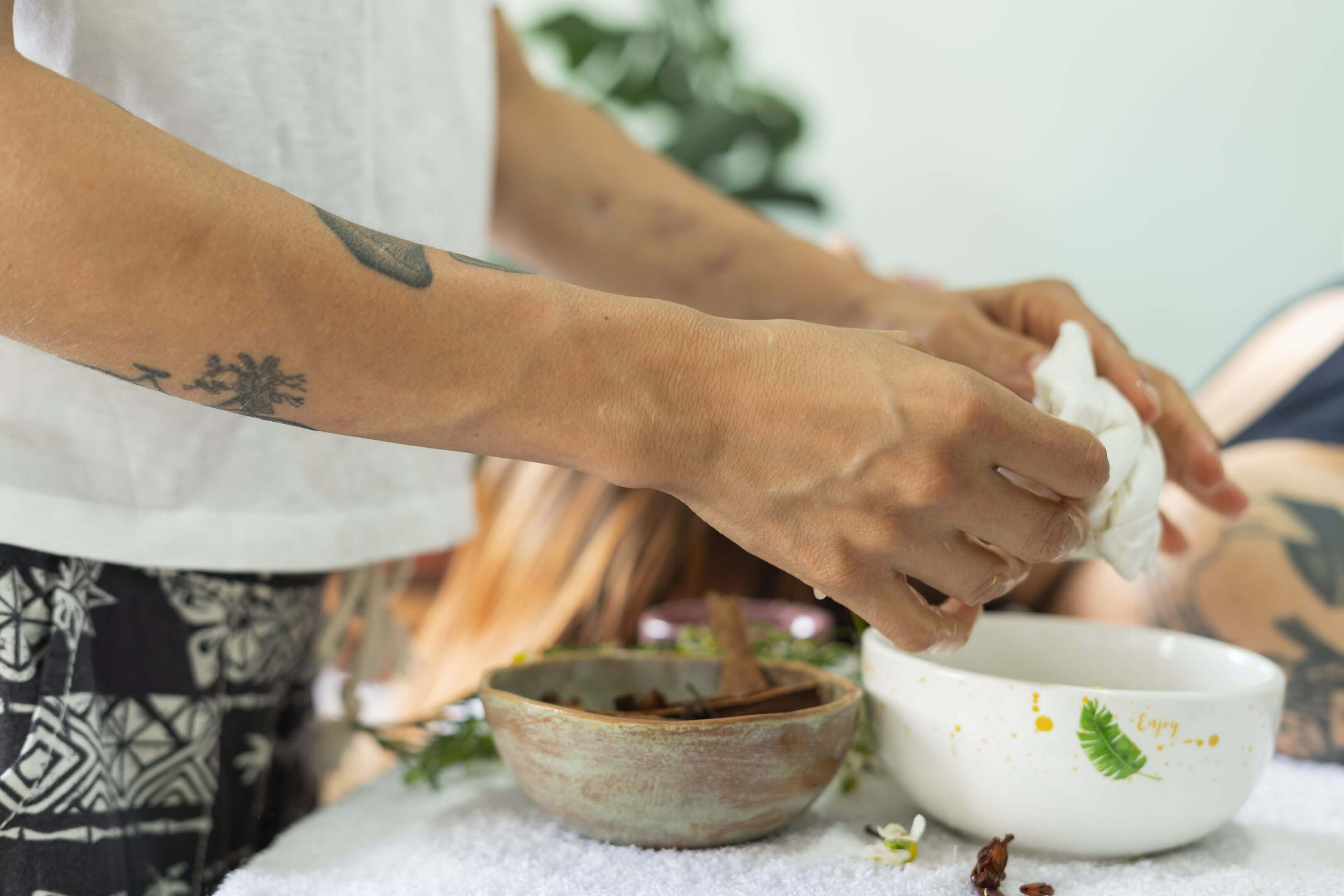 Person preparing spa treatment with bowls.