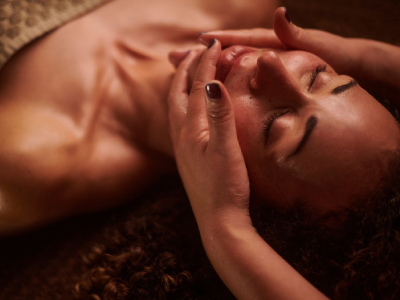 Person receiving relaxing facial massage, eyes closed.