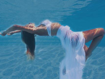 Underwater dancer in flowy white dress.