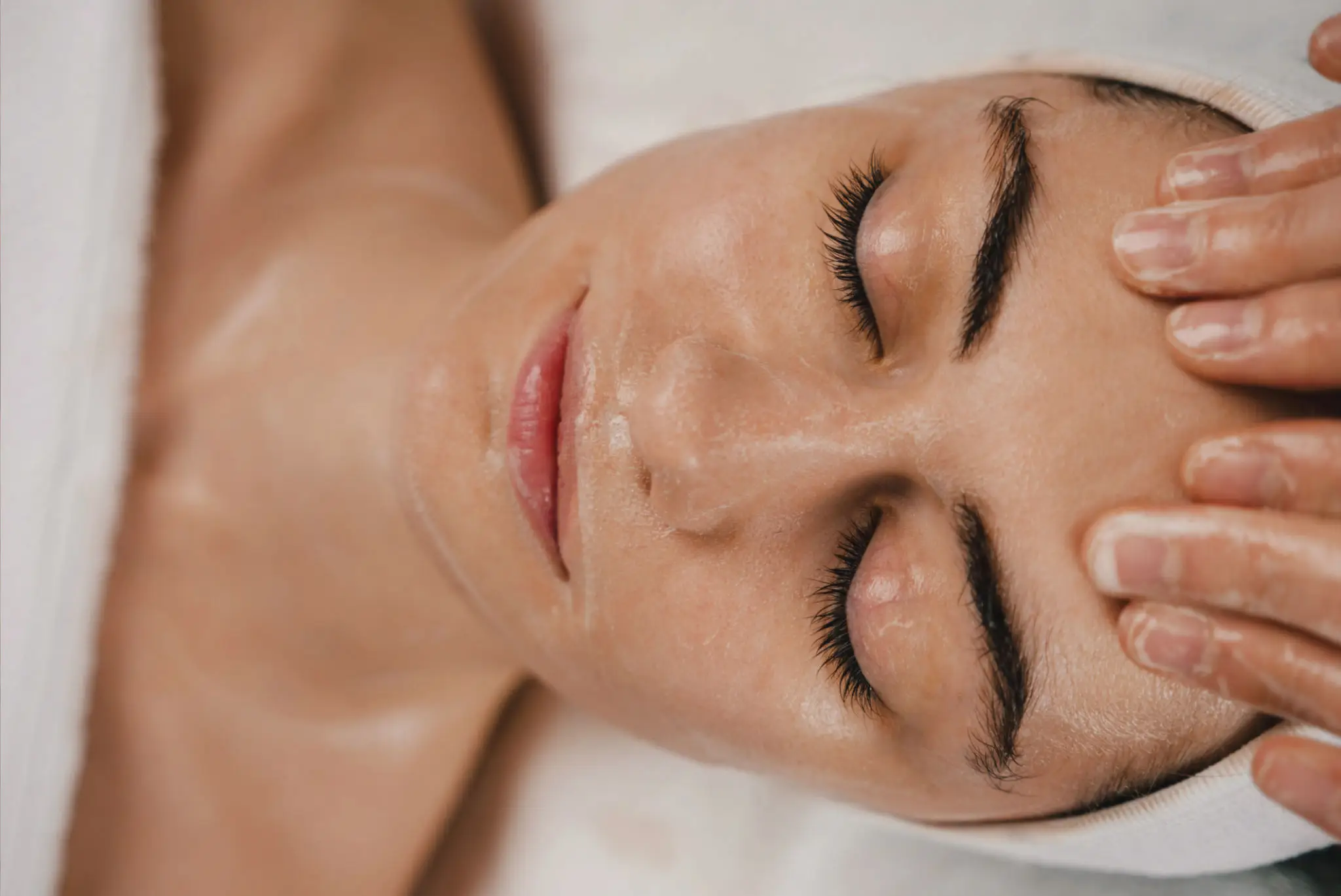 Woman receiving relaxing facial massage therapy.